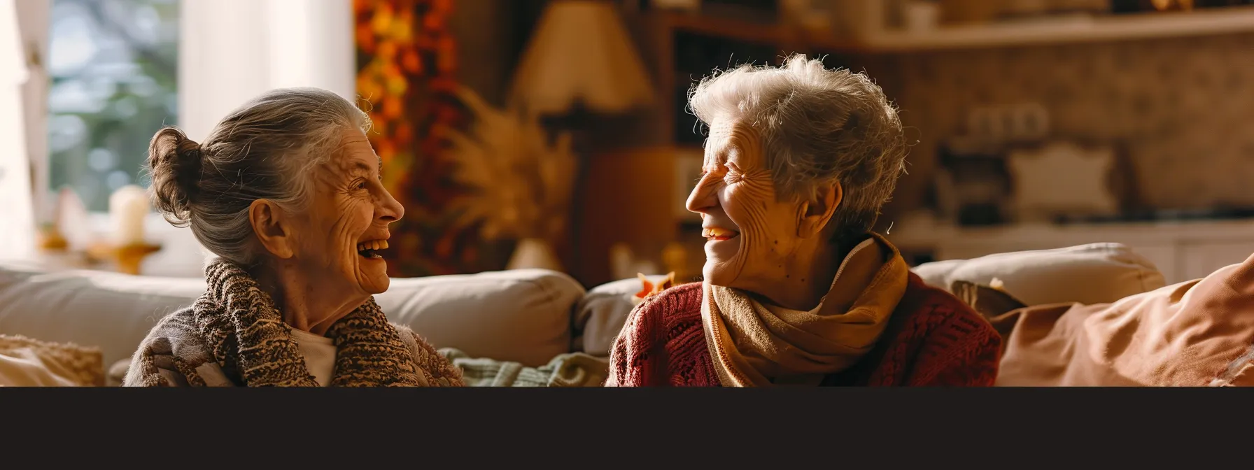 a smiling elderly woman and caregiver enjoying a cheerful conversation in a cozy living room setting.